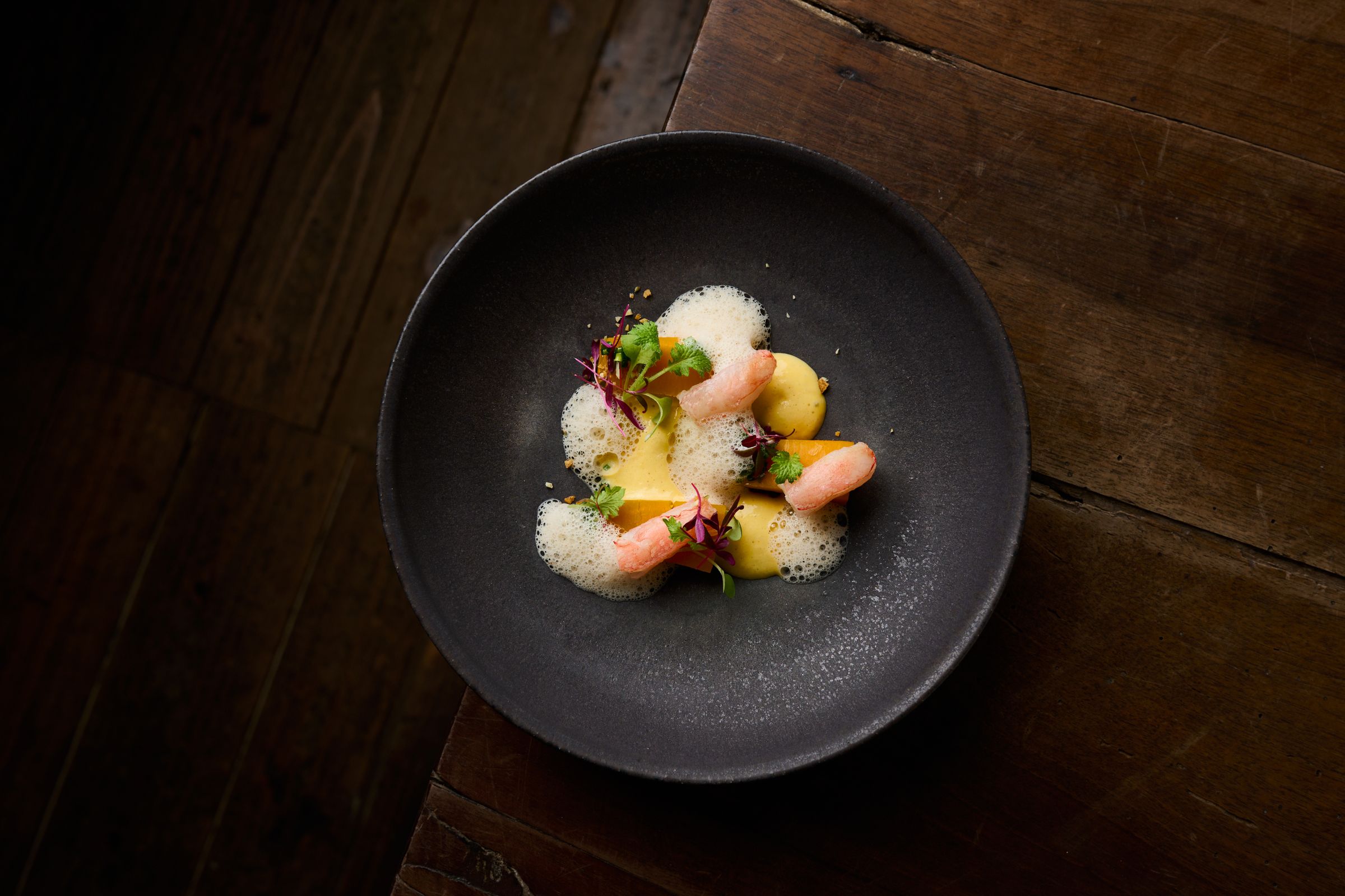 A course on dark stoneware: shellfish, foam and sea herbs